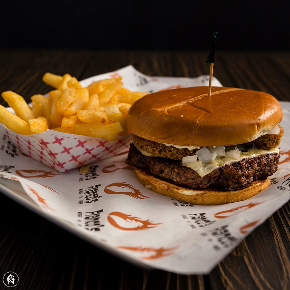 Franco's Wings N More burger with cheese, onions, and a side of golden fries.